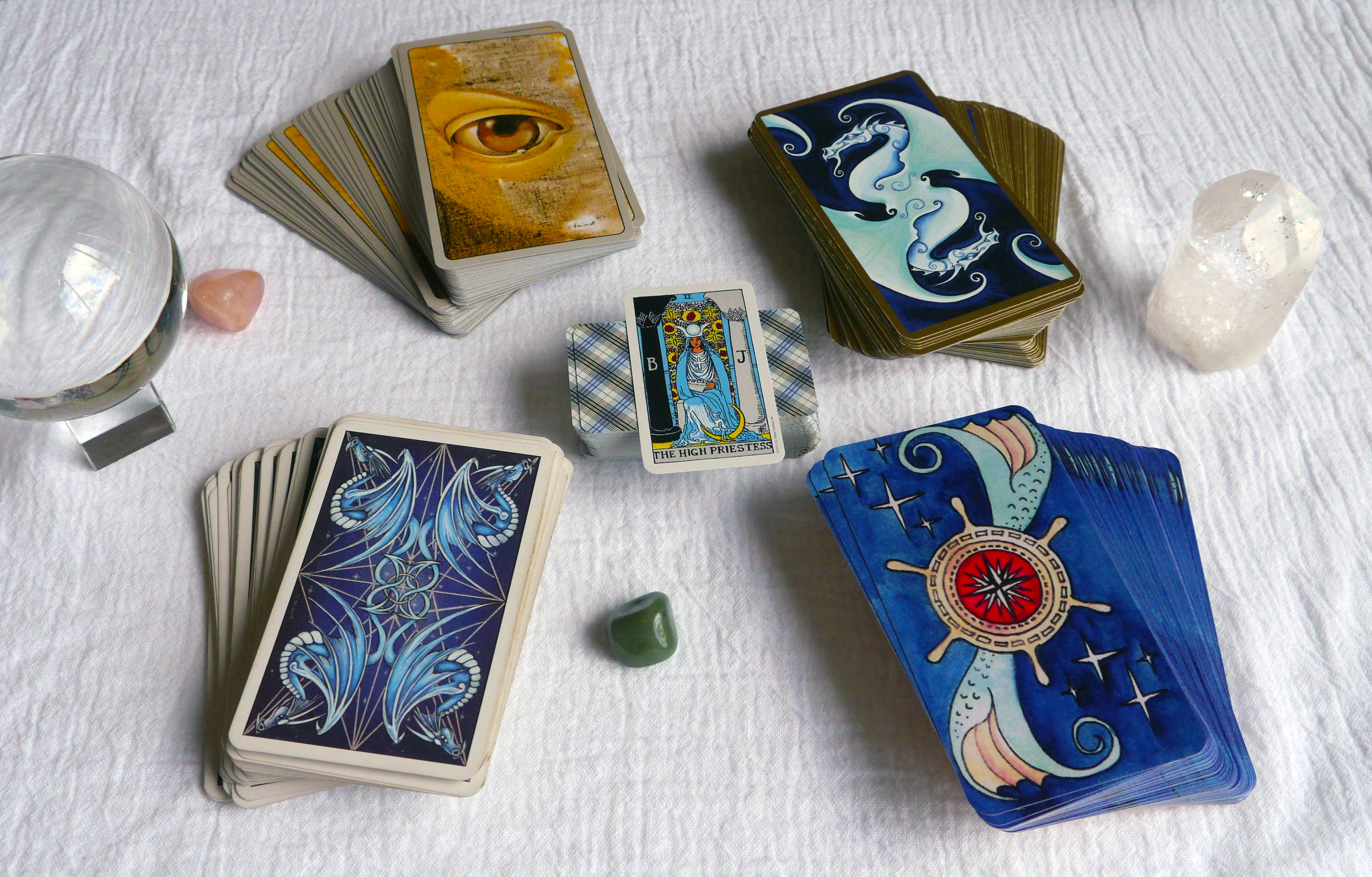 In the center: mini Rider-Waite-Smith, top left: Haindl Tarot, top right: Fantastical Tarot, bottom left: Dragon Tarot, bottom right: Dame Darcy's Mermaid Tarot