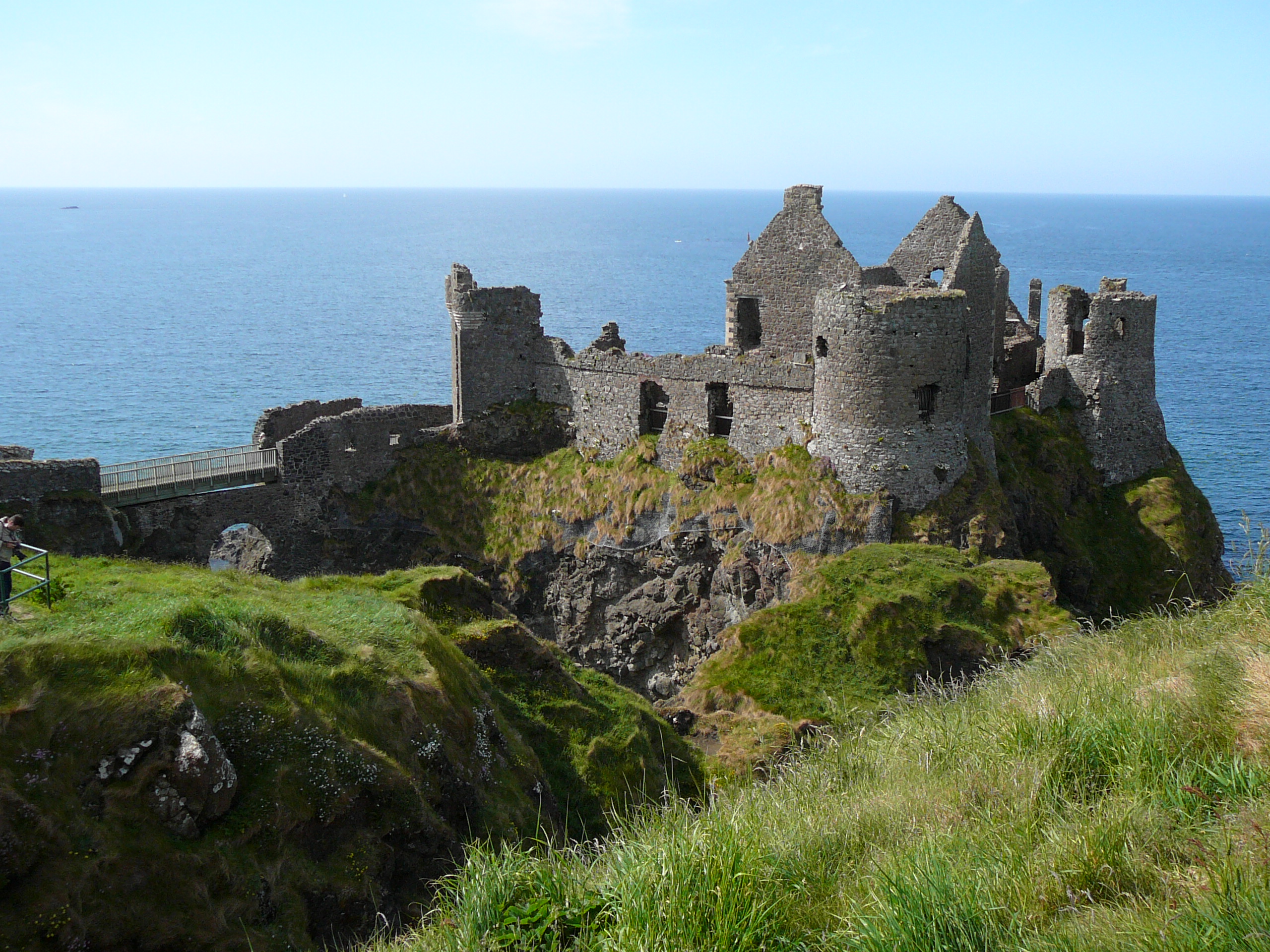 Dunluce Castle ruins on a cliff overlooking the ocean.
