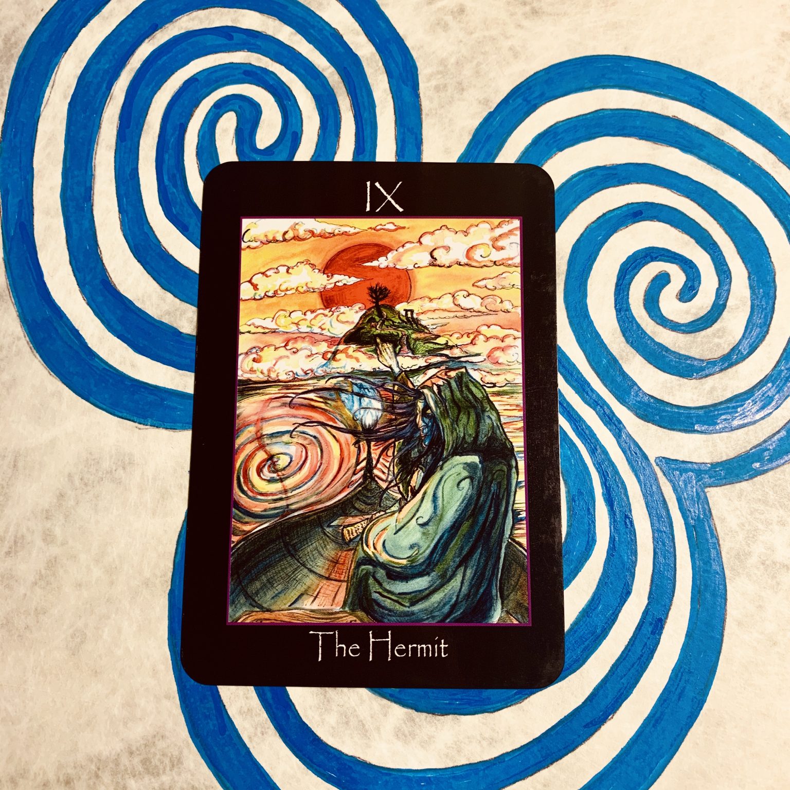 The Hermit card from Tarot Deck of the Sídhe on a Newgrange triple spiral